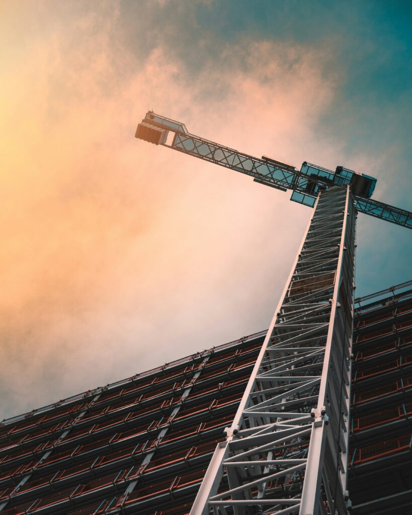 Colour photo looking up towards a crane on a construction site