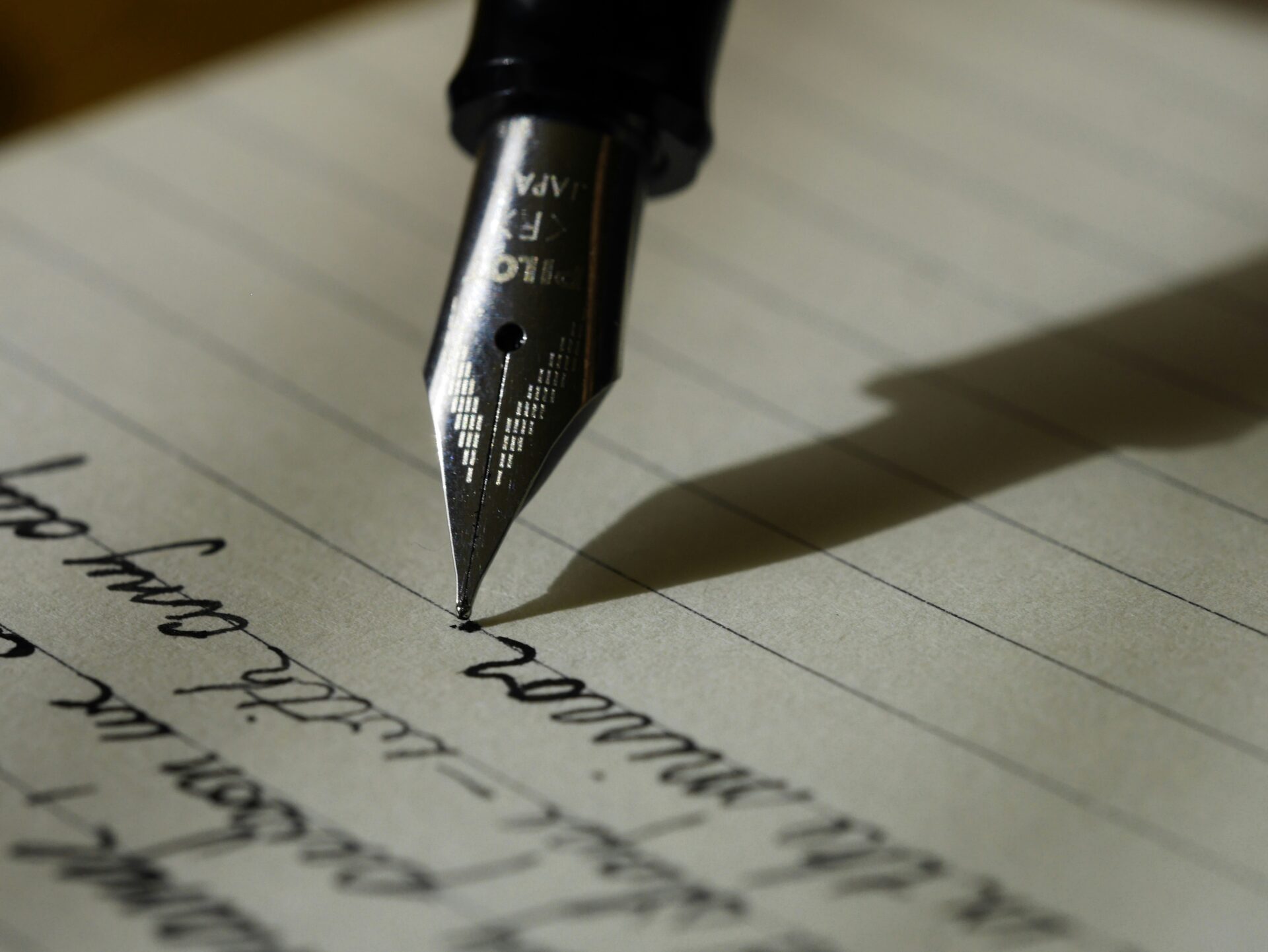 image shows an ink-filled fountain pen writing a letter